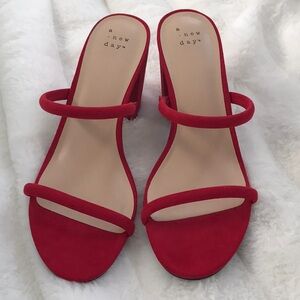 Red suede two-strap heeled sandals with a chunky heel.
